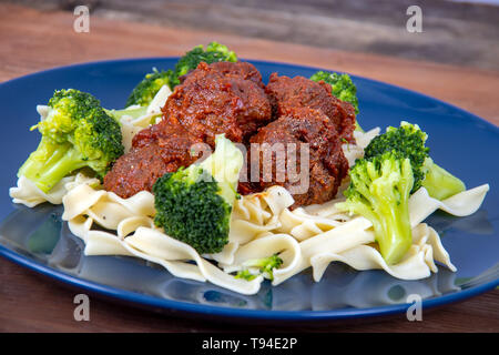 Süße und pikante Fleischbällchen Mahlzeit über Pasta mit Brokkoli Stockfoto