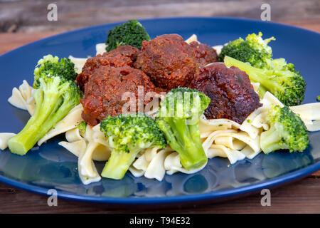 Süße und pikante Fleischbällchen Mahlzeit über Pasta mit Brokkoli Stockfoto