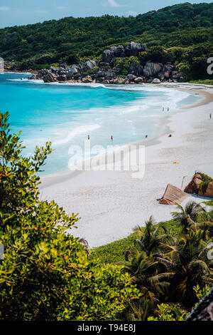 Schönen Grand Anse Strand mit unkenntlich touristische Leute auf La Digue Island auf den Seychellen. Vertikale erschossen. Stockfoto