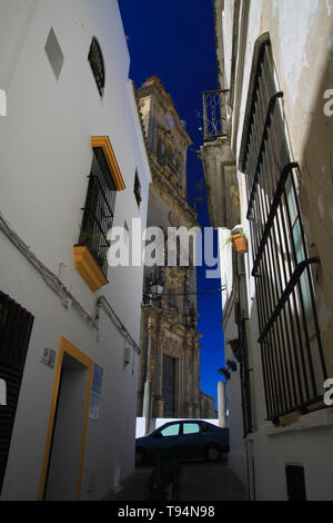 Low Angle View auf schmalen leere Gasse mit Fassaden von Häusern und Schritte im Obergeschoss kontrastieren mit dunkelblauen Himmel in traditionellen spanischen Dorf Arc Stockfoto