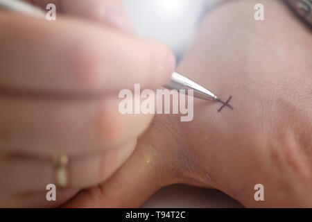 Männliche machen x Kreuz Hinweis mit Silber pen an seinem Arm für Bedenken in Nahaufnahme. Versuchen Sie, nicht zu vergessen zu tun Liste Konzept Stockfoto