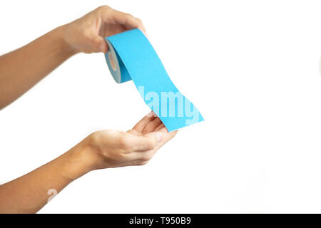 Weibliche Hände halten spezielle Physio Tape Rolle auf weißem Hintergrund Stockfoto