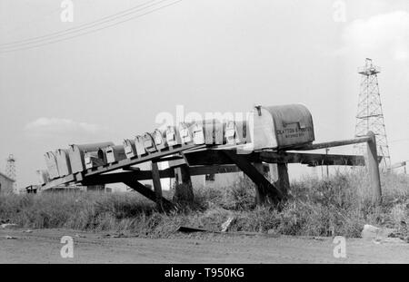 Titel: 'Mail-Boxen, Seminole Ölfeld, Oklahoma." Vor der Einführung des ländlichen Kostenlose Lieferung (RFD) von der Post im Jahr 1896, viele ländliche Bewohner hatten keinen Zugang zu E-Mail, es sei denn Sie sie in einem Postamt viele Meilen entfernt von ihren Häusern gesammelt oder angestellt, ein eigenes Unternehmen zu liefern. Aus diesem Grund, Mailboxen nicht beliebt im ländlichen Amerika geworden, bis Bordsteinkante RFD Zustellung durch die Post war ein etablierter Service. Stockfoto