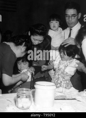 "Umsiedler japanischer Abstammung geimpft werden, da sie für die Evakuierung registrieren." Der internierung der Japaner während des Zweiten Weltkriegs war die Zwangsumsiedlung und Internierung in Lagern von 110,000-120,000 Menschen japanischer Abstammung (62 % der Internierten wurden US-Bürger) durch Präsident Roosevelt kurz nach Japans Angriff auf Pearl Harbor bestellt. Japaner wurden auf der Grundlage der lokalen Bevölkerung Konzentrationen und regionale Politik eingesperrt. Stockfoto