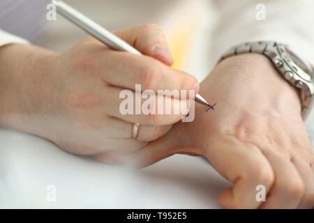Männliche machen x Kreuz Hinweis mit Silber pen an seinem Arm für Bedenken in Nahaufnahme. Versuchen Sie, nicht zu vergessen zu tun Liste Konzept Stockfoto