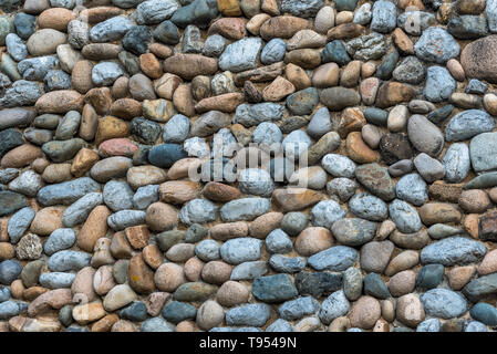 Verschiedene Arten von Steinen und Kies ähnlicher Größe auf einem flachen Gebäude Oberfläche Stockfoto