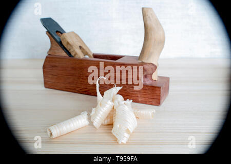 Späne nach dem Hobeln von Holz Esche auf dem Hintergrund der Ebene schließen oben. DIY-Konzept. Holzbearbeitung und Handwerk Werkzeuge. Zimmerei Handwerkzeuge. Holz- Bac Stockfoto