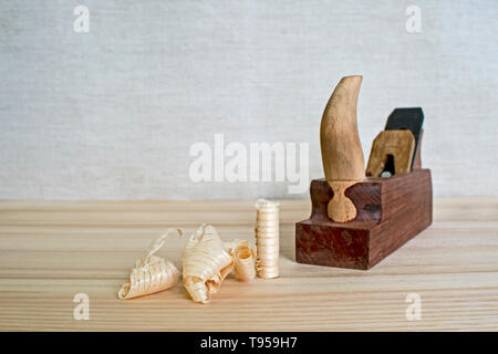 Späne nach dem Hobeln von Holz Esche auf dem Hintergrund der Ebene schließen oben. DIY-Konzept. Holzbearbeitung und Handwerk Werkzeuge. Zimmerei Handwerkzeuge. Holz- Bac Stockfoto