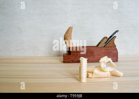 Späne nach dem Hobeln von Holz Esche auf dem Hintergrund der Ebene schließen oben. DIY-Konzept. Holzbearbeitung und Handwerk Werkzeuge. Zimmerei Handwerkzeuge. Holz- Bac Stockfoto