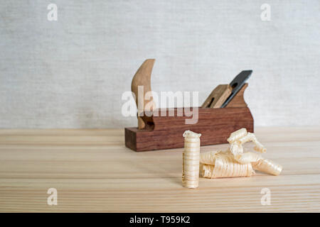 Späne nach dem Hobeln von Holz Esche auf dem Hintergrund der Ebene schließen oben. DIY-Konzept. Holzbearbeitung und Handwerk Werkzeuge. Zimmerei Handwerkzeuge. Holz- Bac Stockfoto