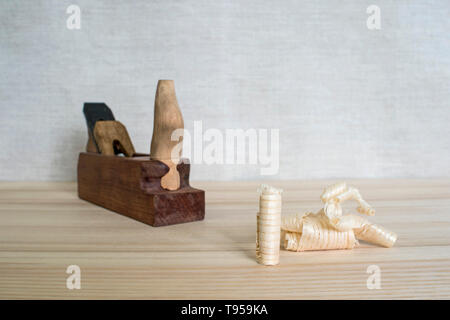 Späne nach dem Hobeln von Holz Esche auf dem Hintergrund der Ebene schließen oben. DIY-Konzept. Holzbearbeitung und Handwerk Werkzeuge. Zimmerei Handwerkzeuge. Holz- Bac Stockfoto