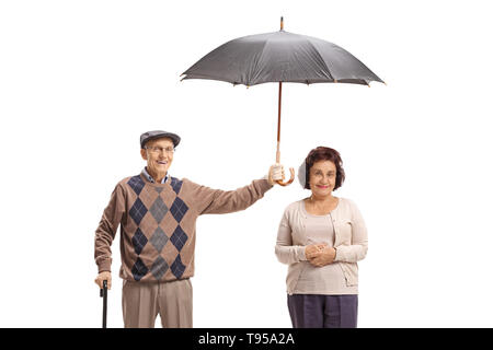 Ältere Herr Holding einen Regenschirm über eine ältere Dame auf weißem Hintergrund Stockfoto