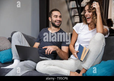 Fröhlicher junger Paare entspannt auf der Couch zu Hause Stockfoto