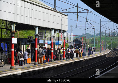 Passagiere warten auf einen Zug auf der Northbound platform Oxenholme Bahnhof, West Coast Main Line, Cumbria, England, Vereinigtes Königreich, Europa. Stockfoto