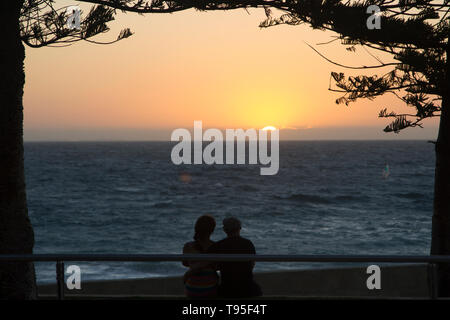 Schöne Szene Sonnenuntergang und ein paar Beobachten der Horizont in der Strand, Perth, Australien. Stockfoto