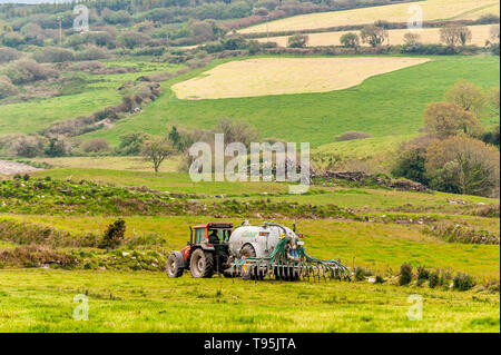 Ballydehob, West Cork, Irland. 16. Mai, 2019. Ein Landwirt spreads Gülle mit einem sekundärbacke slurry Spreader auf ein sehr bedeckt und trübe Tag. Es gibt vereinzelt Regen für den Rest des Tages mit Top temps mit 14 bis 18 °C betragen. Credit: Andy Gibson/Alamy Leben Nachrichten. Stockfoto