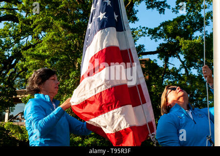 Southern Pines, North Carolina, USA. 16. Mai, 2019. Mai 16, 2019 - Southern Pines, North Carolina, USA - BONNIE McGOWAN, Links, und ihre Schwester, Peggy, Miller, sowohl der südlichen Kiefern und Töchter der späten Peggy Kirk Bell, heben Sie die amerikanische Flagge bei der Eröffnungsfeier in der ersten Runde die USGA 2 U.S. Senior Frauen Offene Meisterschaft im Pine Needles Lodge and Golf Club, 16. Mai 2019 in Southern Pines, North Carolina. Peggy Kirk Bell, merkte Golf der Frauen befürworten, Lehrer, ehemalige LPGA Tour player, und World Golf Hall of Fame Mitglied, im Besitz von Tannennadeln vor ihrem Tod im Jahr 2016. Pi Stockfoto