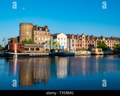 Leith Docks, Edinburgh, Schottland, Großbritannien, 16. Mai 2019. UK Wetter: ein sonniger Tag geht zu Ende über den Hafen in Leith mit Gebäuden und Lastkähne auf dem Ufer von den letzten Strahlen der Sonne spiegelt sich im Wasser des Leith Fluss lit Stockfoto