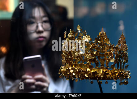 (190517) - Peking, 17. Mai 2019 (Xinhua) - eine Frau sieht eine goldene Krone während einer Afghanischen kulturelle Relikte in Zhengzhou in der zentralen Provinz Henan, China am 25. Mai 2018 zeigen. (Xinhua/Li Jianan) Stockfoto