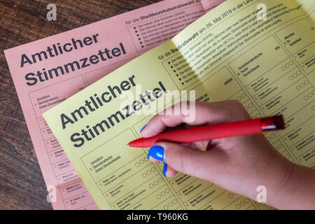17. Mai 2019, Sachsen, Dresden: Illustration - eine Frau hält einen Stift über einen Stimmzettel für die Briefwahl für die Kommunalwahlen in Sachsen. Foto: Robert Michael/dpa-Zentralbild/dpa Stockfoto