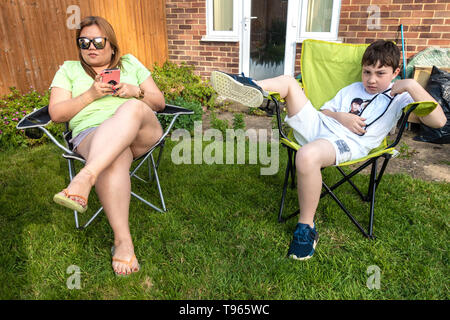 Porträt einer Mutter und Sohn saß in einem Klappstuhl, im Garten entspannen. Stockfoto