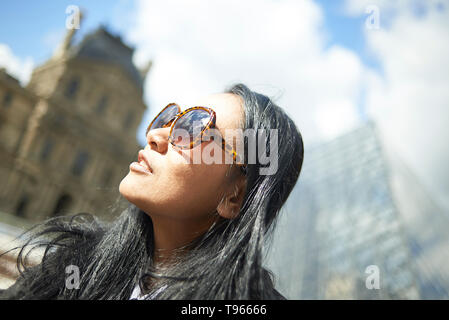 Asiatische Frau steht vor dem Louvre Museum im Stadtzentrum von Paris im Frühling Sonnenschein Stockfoto