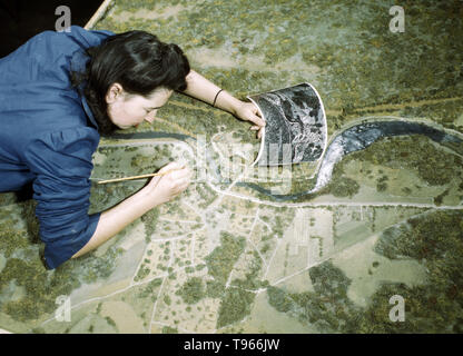 Camouflage Klasse an der New York University, wo Männer und Frauen Vorbereitung für Jobs in der Armee oder in der Industrie sind, New York, N.Y. dieses Modell ist getarnt und fotografiert worden. Das Mädchen ist die Korrektur versehen in der Tarnung eines Modells Verteidigung Pflanze fotografiert von Marjory Collins, 1943 erkannt. Stockfoto