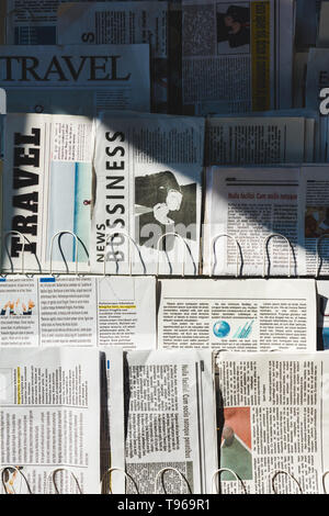 Unterschiedliche print Business und Reisen Zeitung am Stand in der Sonne Stockfoto