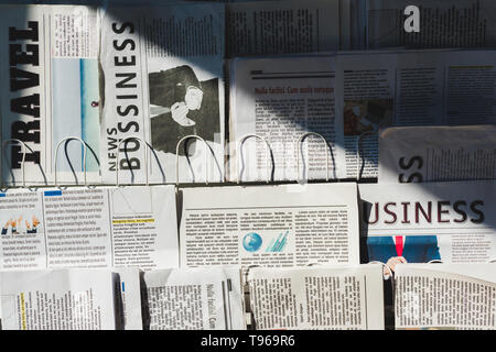 Unterschiedliche print Business und Reisen Zeitung am Stand in der Sonne Stockfoto