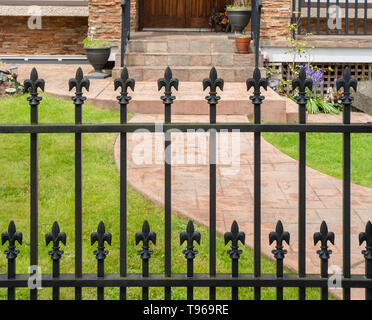 Black Metal grid Zaun von Wohnhaus mit Lily geformten Tischplatten. Stockfoto