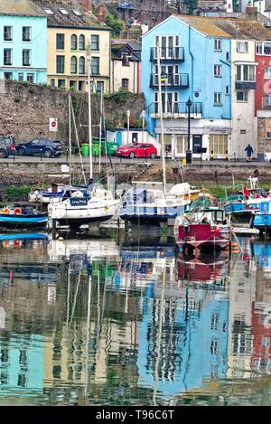 Abstrakten Reflexionen im Wasser der Boote und bunte Häuser im Hafen von Brixham, Devon, England Großbritannien Stockfoto