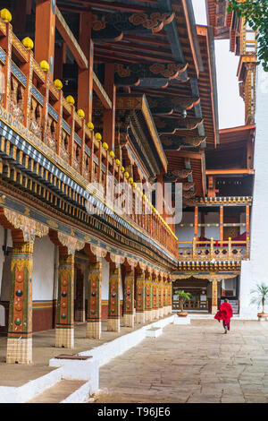 Buddhistischer Mönch, der durch den Hof des Klosters und Festung Punakha Dzong, Bhutan läuft Stockfoto