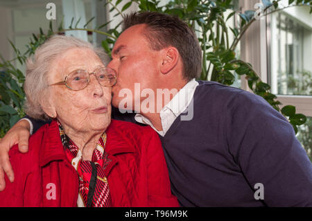 Ältere Frau geküsst von Sohn Stockfoto