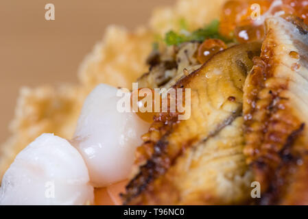 Typische japanische Fisch donburi, Shrimp Tempura, rohe Garnelen, Lachs Filets, gegrillter Thunfisch, Kaviar, Thunfisch Tartar, in Scheiben geschnittene Gurken, raw Wolfsbarsch Fischfilets Stockfoto