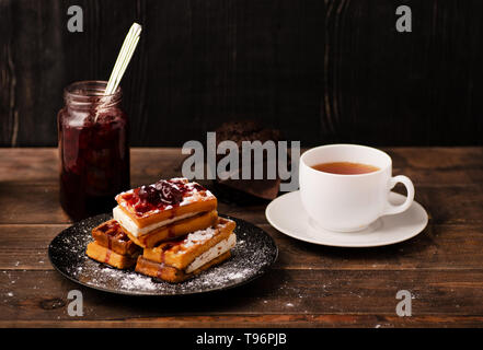 Wiener Waffeln mit Pulver und Beeren, Tee, Marmelade und Muffin Stockfoto