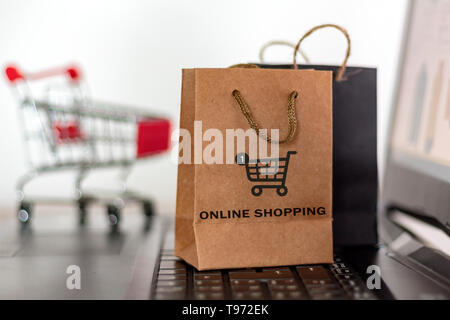 Shopping Taschen und Trolley auf dem Laptop. Online Shopping, e-commerce Konzept Stockfoto