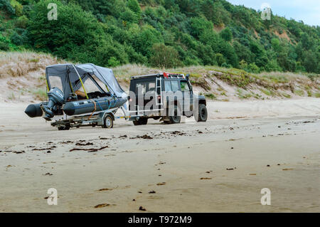 Jeep mit Anhänger und Boot am Strand, Boot auf Trailer am Auto, Ostsee Küste, Region Kaliningrad, Russland, 11. August 2018 Stockfoto