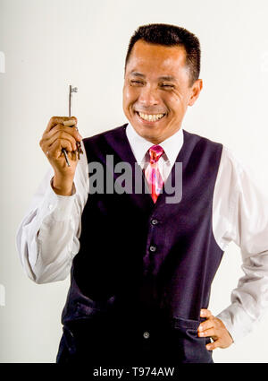 Ein lächelndes Asian American Railroad service Attendant zeigt seine Sicherheitsschlüssel auf der Los Angeles train Yards. MODEL RELEASE Stockfoto