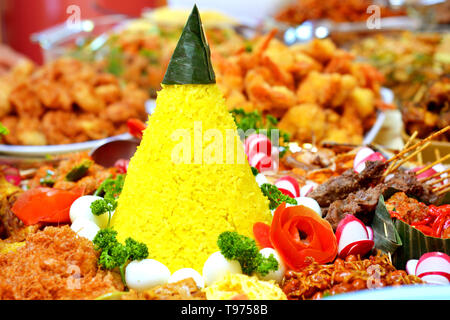 Nasi Tumpeng oder Konische Gelber Reis mit traditionellen Speisen aus Indonesien Stockfoto