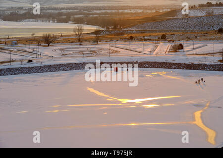 Sonnenuntergang Eisigen See - ein paar Leute sind Eis - Angeln auf einem zugefrorenen See bei Chatfield State Park auf einem sehr kalten Winter Abend. Denver-Littleton, Colorado, USA. Stockfoto