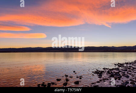 Orange Wolken - Helle farbe orange Sonnenuntergang Wolken über zugefrorene Chatfield Behälter am Fuße der Front Range der Rocky Mountains rollen. Colorado, USA. Stockfoto