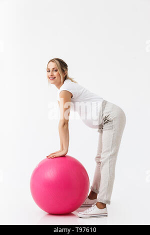 Volle Länge eines schönen jungen schwangeren Frau sport Übungen mit Fitness Ball auf weißem Hintergrund Stockfoto