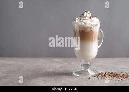 Glas kalten Kaffee mit Schlagsahne auf grau Tisch Stockfoto