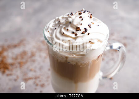 Glas kalten Kaffee mit Schlagsahne auf grau Tisch Stockfoto