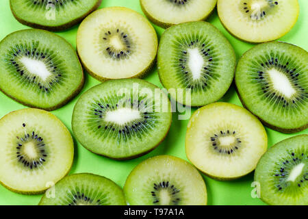 Horizontale Ansicht der Schichten des goldenen gelb und grün Kiwi auf einem hellen Kontrast grüner Hintergrund Stockfoto