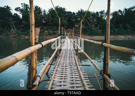 Holzbrücke über Nam Khan rive in Luang Prabang, Laos. Alte gefährliche Brücke von Bambus. Perspektivische Ansicht Stockfoto