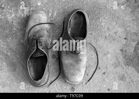 Zwei alte Schuhe in die entgegengesetzte Richtung platziert und von oben gesehen. Schwarz und Weiß. Kopieren Sie Platz Stockfoto