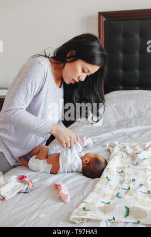 Chinesische Asiatische besetzt Mutter ändern Windeln für neugeborene baby Sohn Tochter. Home Lifestyle echte natürliche Familie Moment. Muttertag. Stockfoto