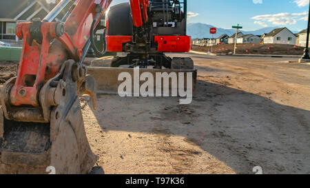 Panorama Nahaufnahme von einem roten Bagger mit einem angehängt ist graderblatt an einem sonnigen Tag gesehen Stockfoto