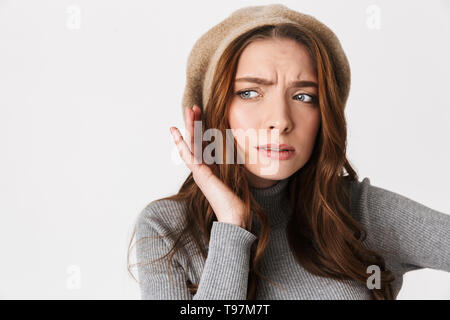 Portrait Nahaufnahme von konzentrierte sich Frau 30 s Tragen hat versucht, etwas zu hören, während Hand an ihr Ohr auf weißem Hintergrund halten. Stockfoto